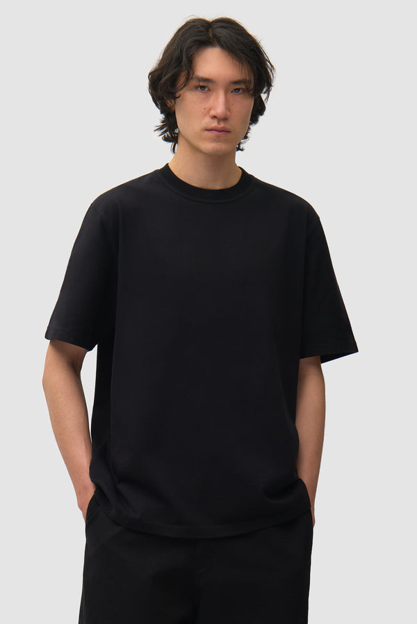 아르테 T-shirt in Black worn by a model, half-body front view