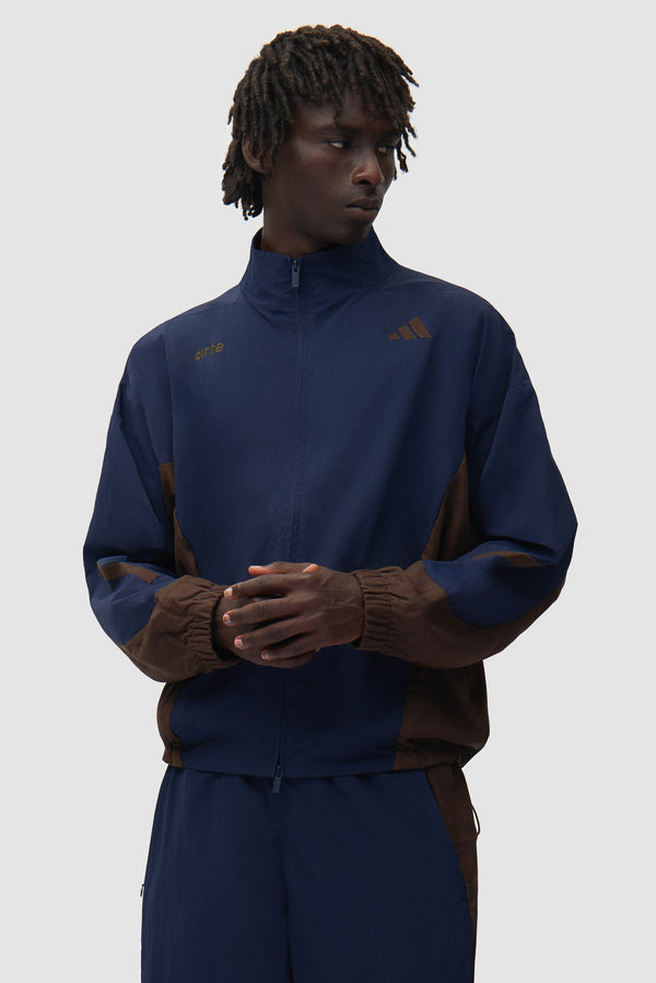 Arte for adidas Z.N.E. track top in Navy/Brown worn by a model, full-body front view