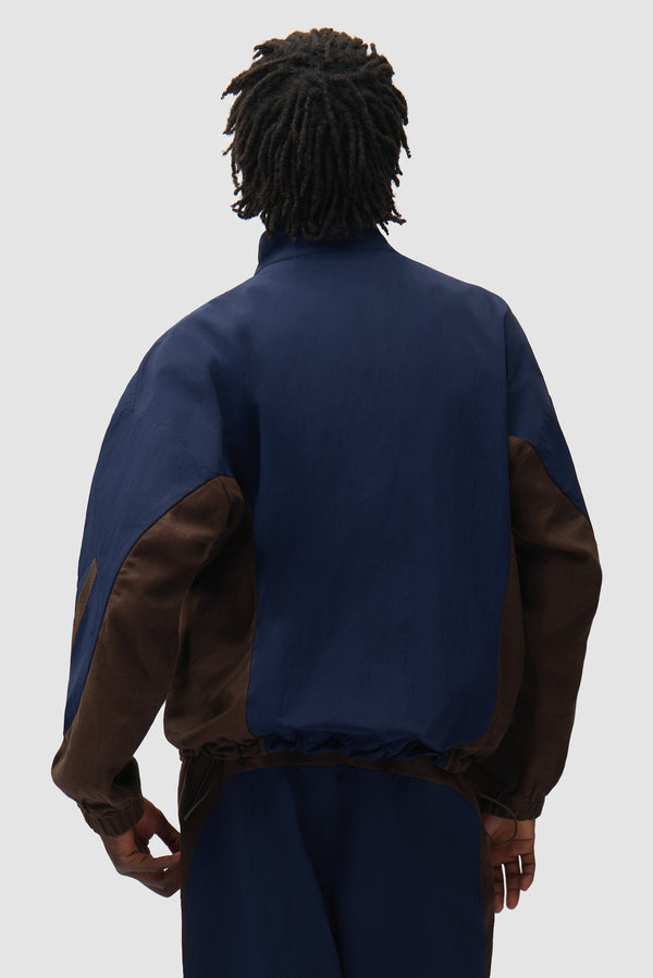 Arte for adidas Z.N.E. track top in Navy/Brown worn by a model, half-body back view