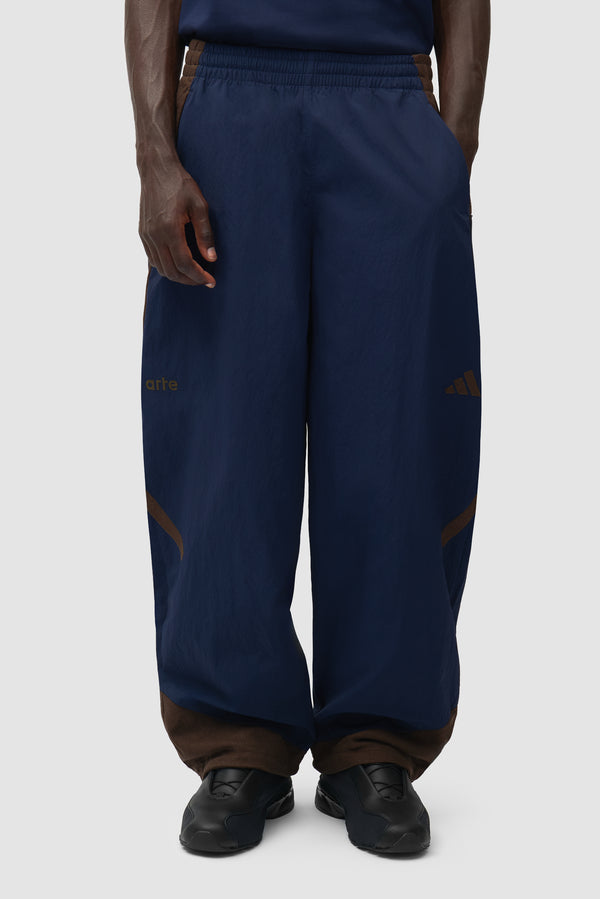 Arte for adidas Z.N.E. track pants in Navy/Brown worn by a model, half-body front view