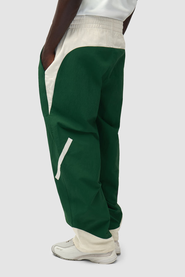 Arte for adidas Z.N.E. track pants in Green/Cream worn by a model, half-body back view