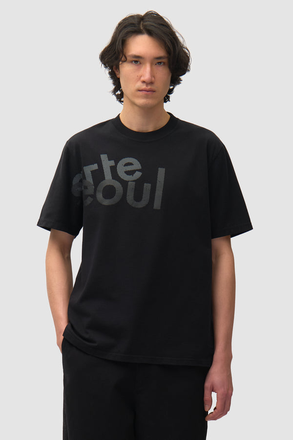 Arte/Seoul T-shirt in Black worn by a model, half-body front view