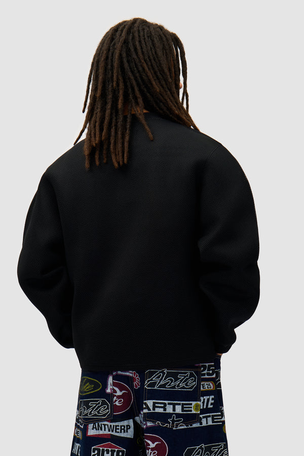 Mesh Crewneck in Black worn by a model, half-body back view