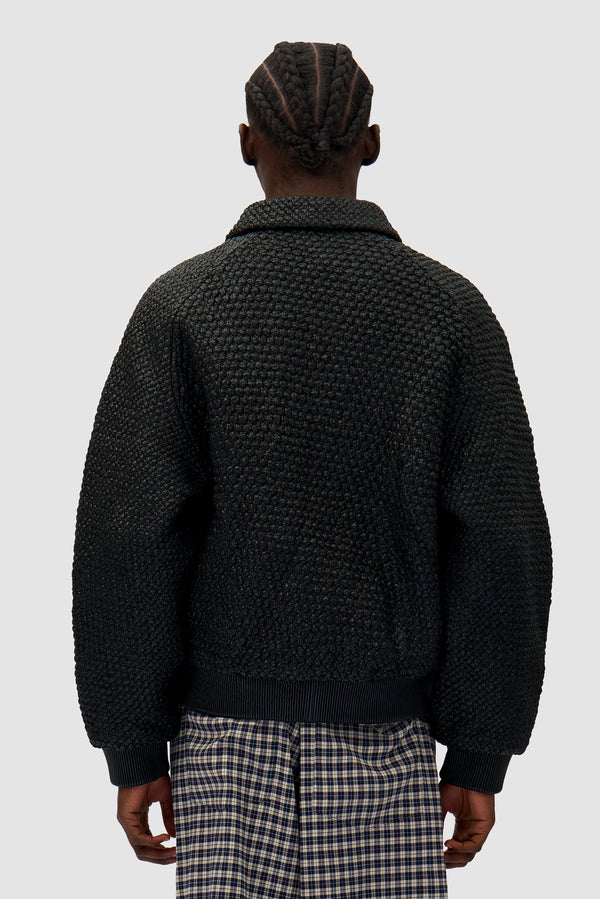 Leather Braided Jacket in Black worn by a model, half-body back view
