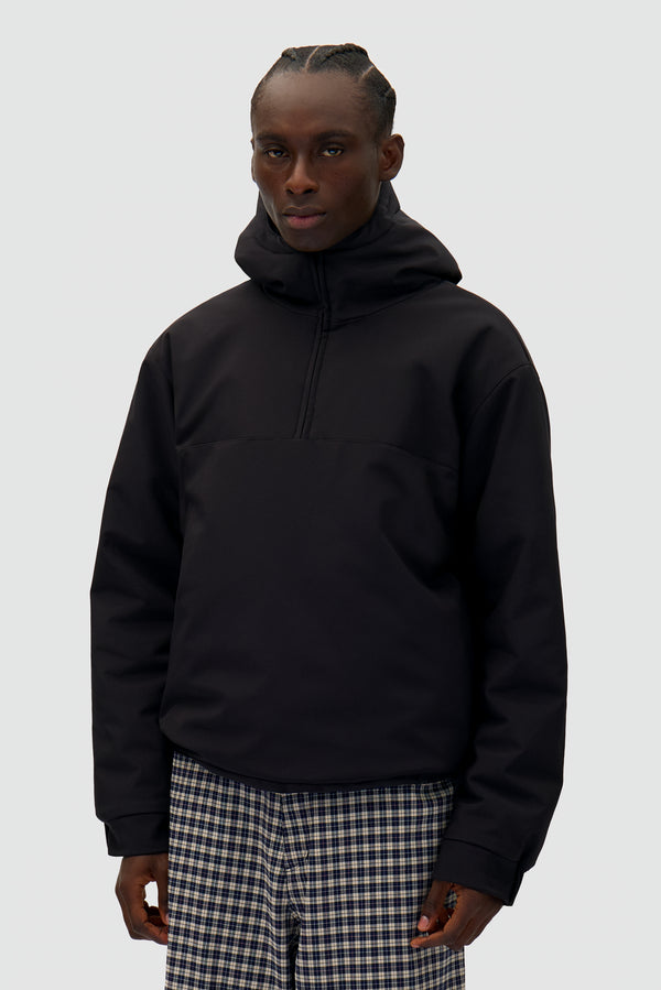 Technical Anorak in Black worn by a model, half-body front view