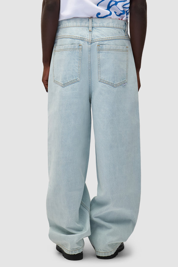 Denim Pants in Bleached Denim worn by a model, half-body side view