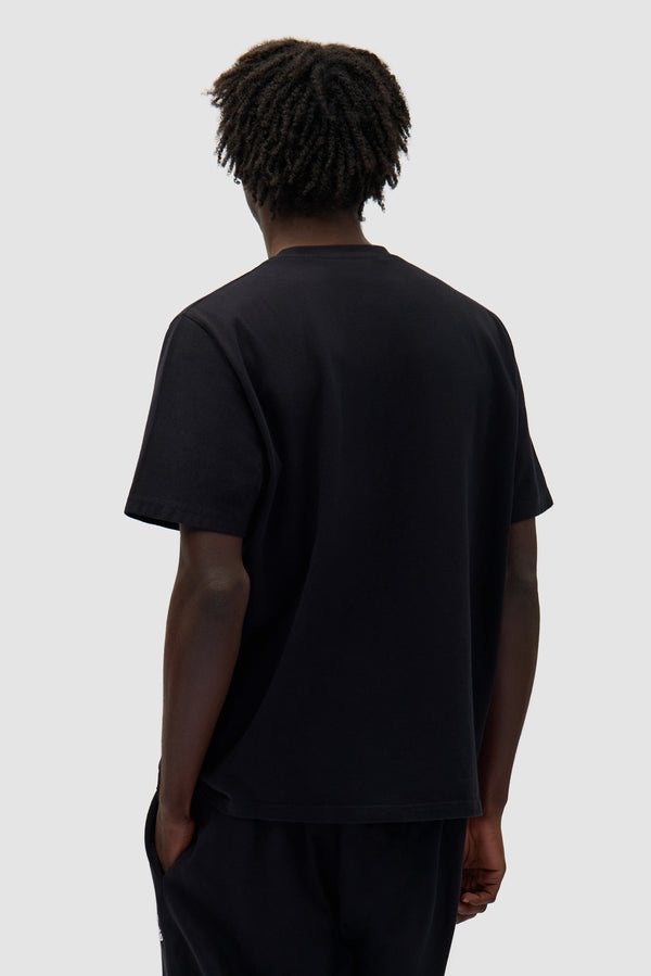 Heart Logo T-shirt in Black worn by a model, half-body back view