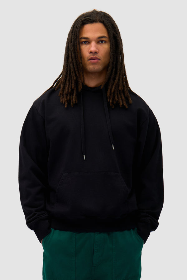Energy Hoodie in Black worn by a model, half-body back view