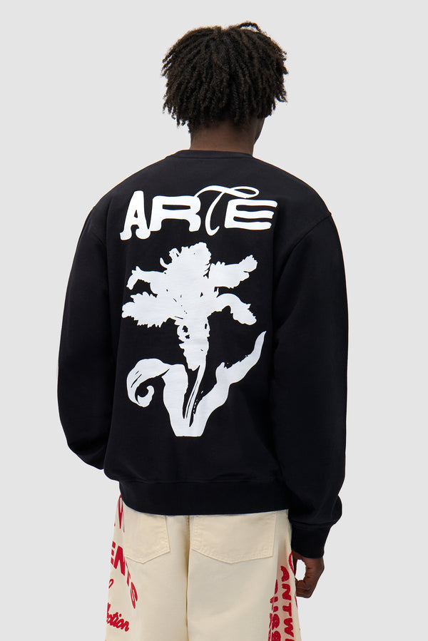 Flower Crewneck in Black worn by a model, half-body back view