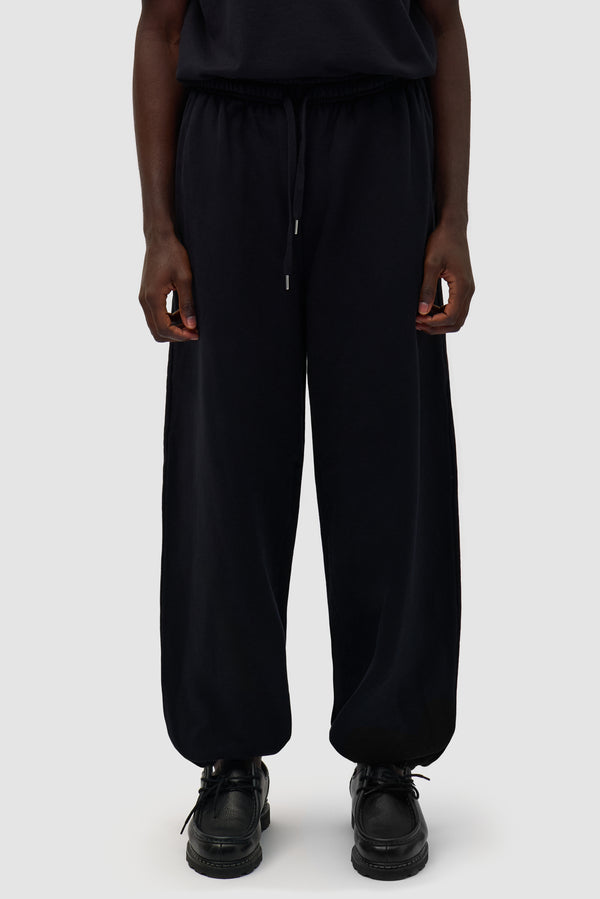 Heart Logo Sweatpants in Black worn by a model, half-body side view