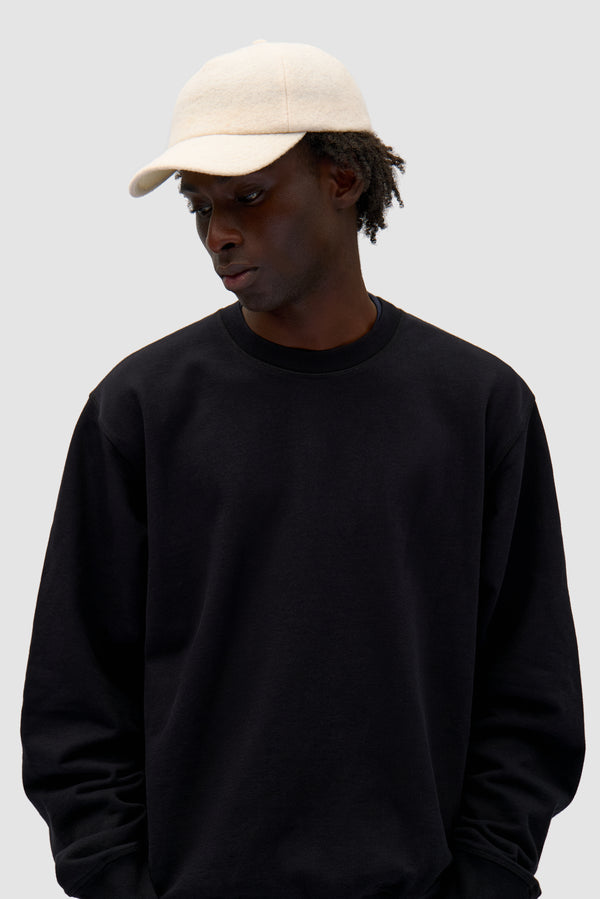 Wool Cap in Cream worn by a model, half-body front view