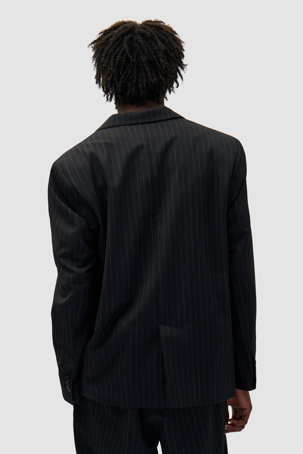 Suit Jacket in Black worn by a model, half-body back view