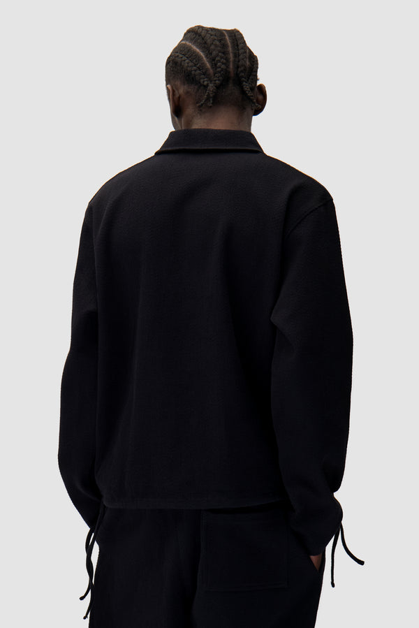 Label Pullover in Black worn by a model, half-body back view