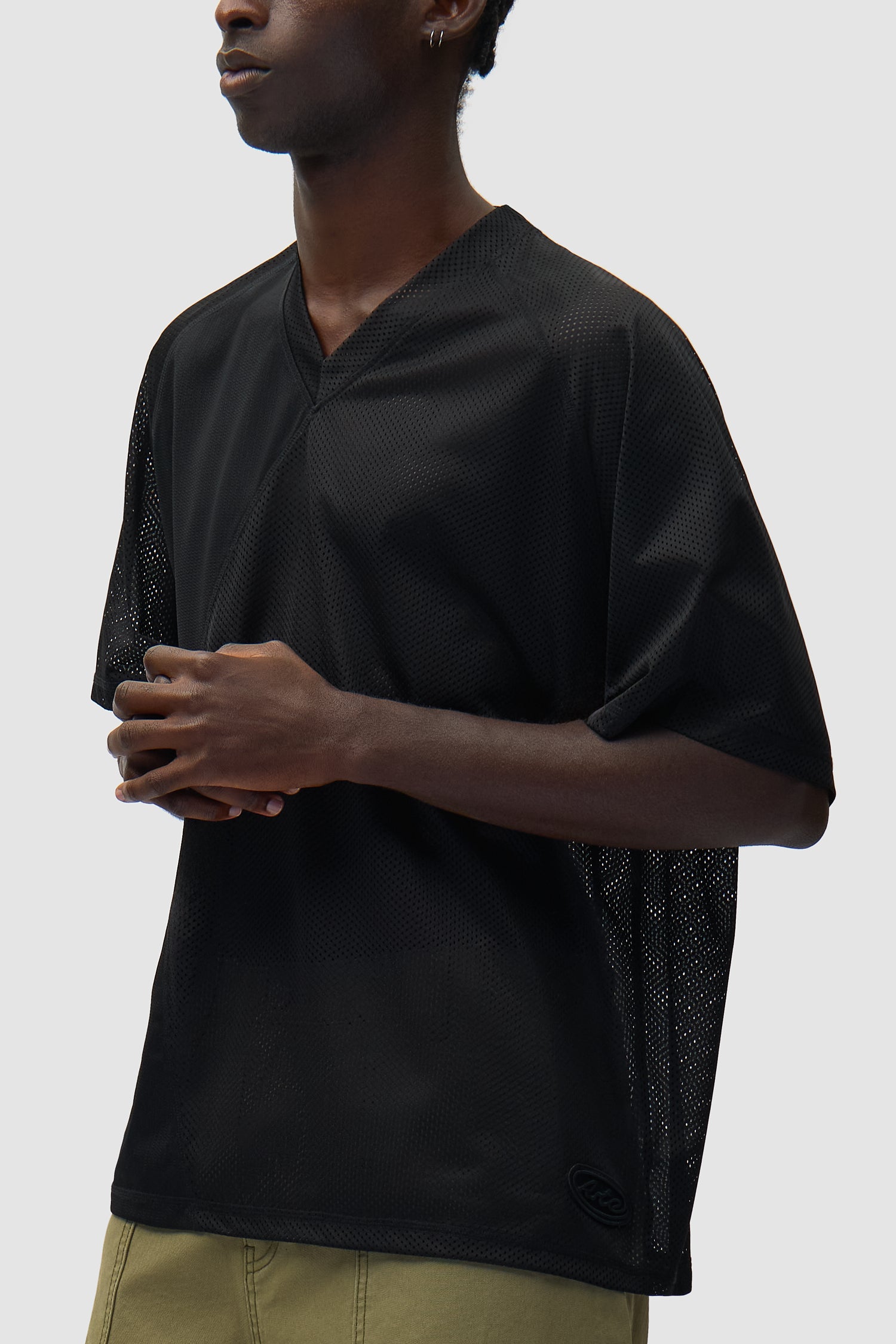 T-shirt Multi Mesh noir porté par un mannequin, vue de profil à mi-corps