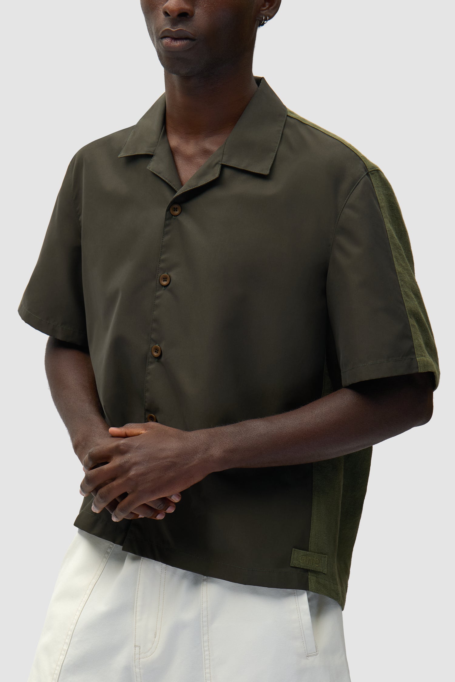 Chemise en lin et nylon verte portée par un mannequin, vue de profil à mi-corps