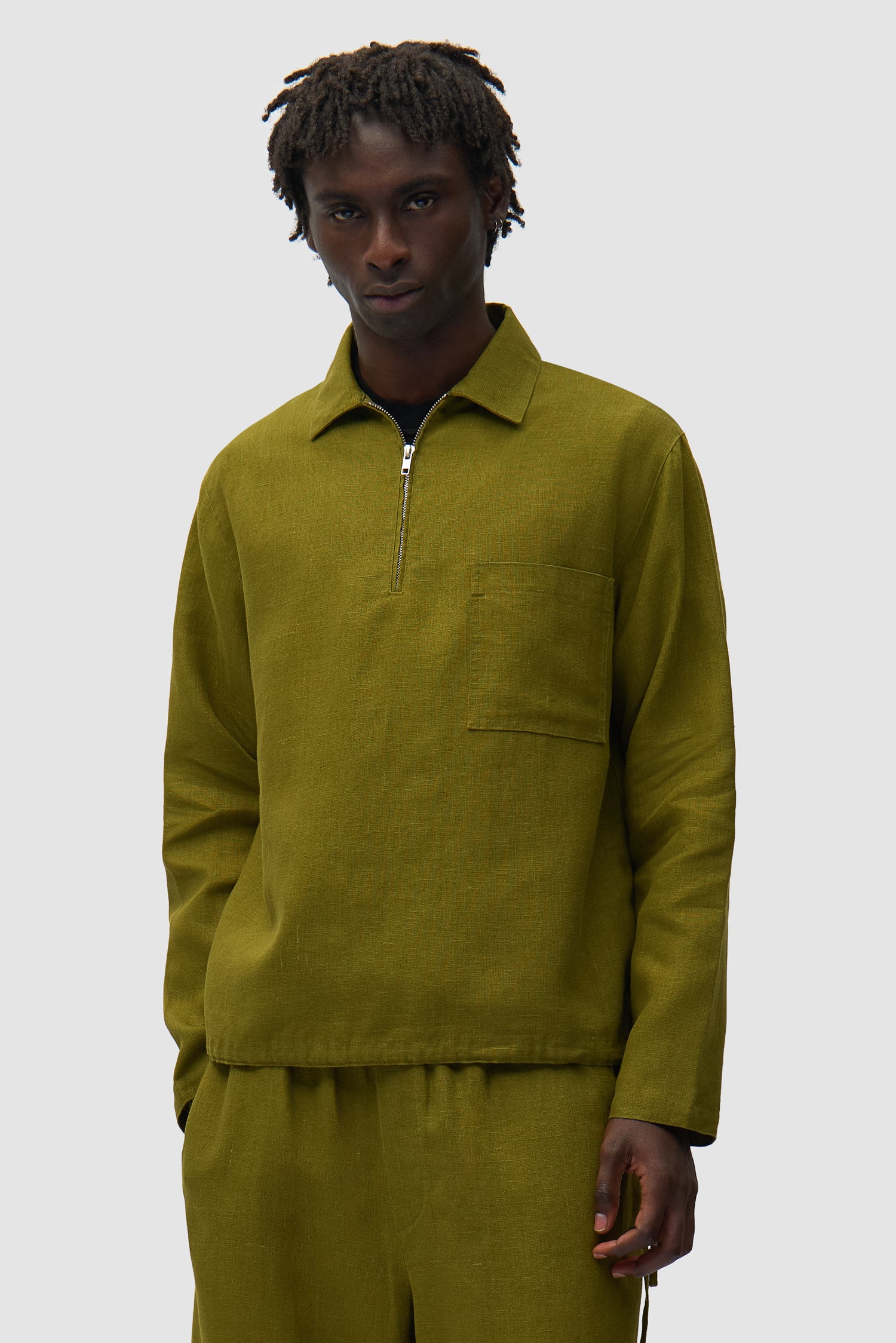 Pull à demi-fermeture éclair en lin vert porté par un mannequin, vue de face en demi-corps