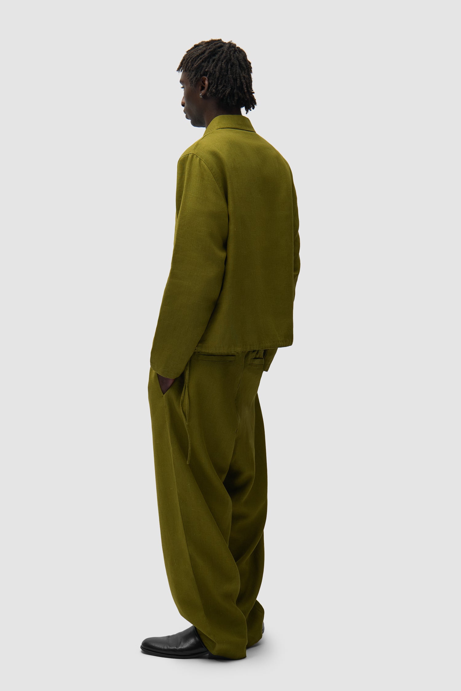 Linen Pants in Green worn by a model, full-body back view