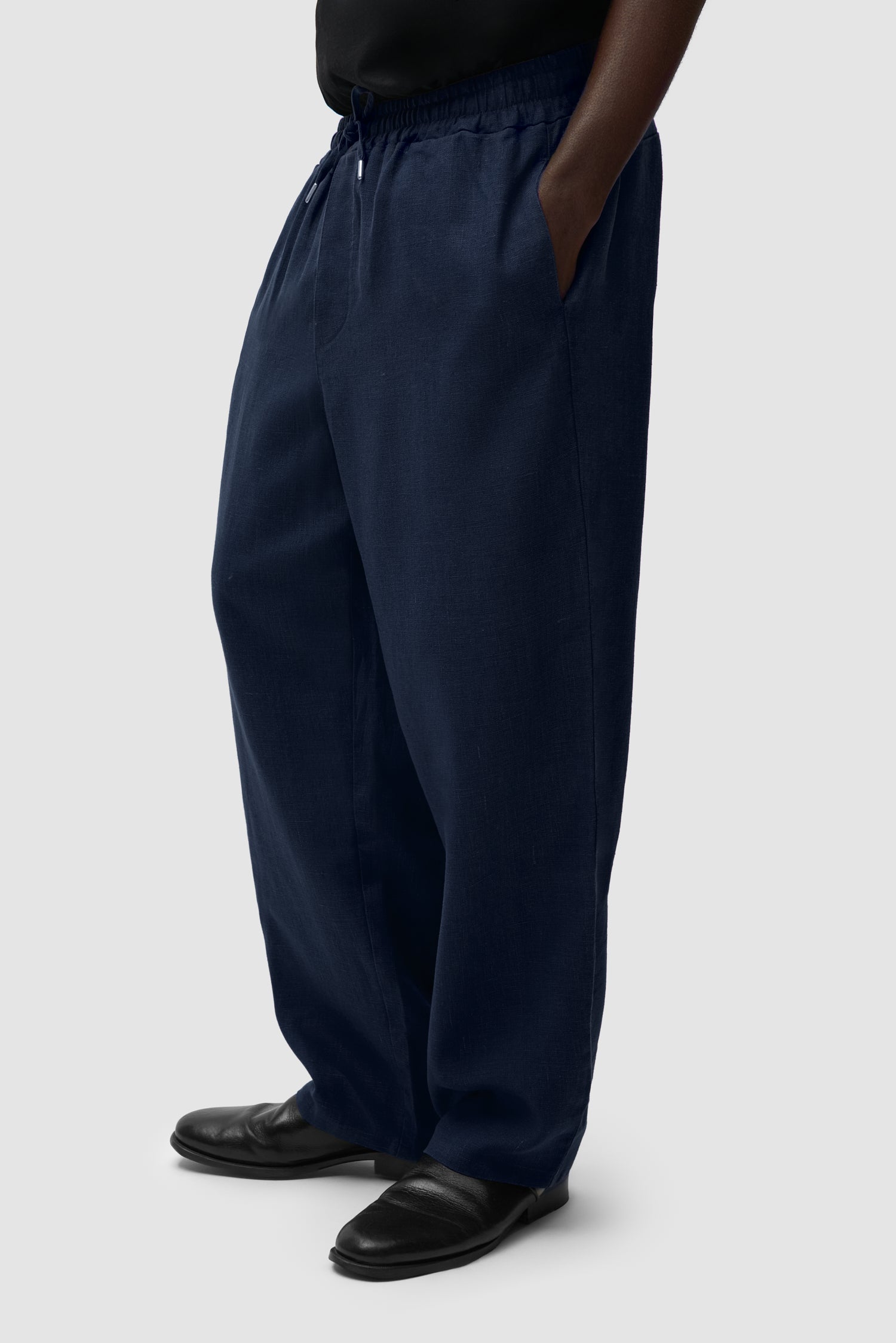 Linen Pants in Navy worn by a model, half-body side view