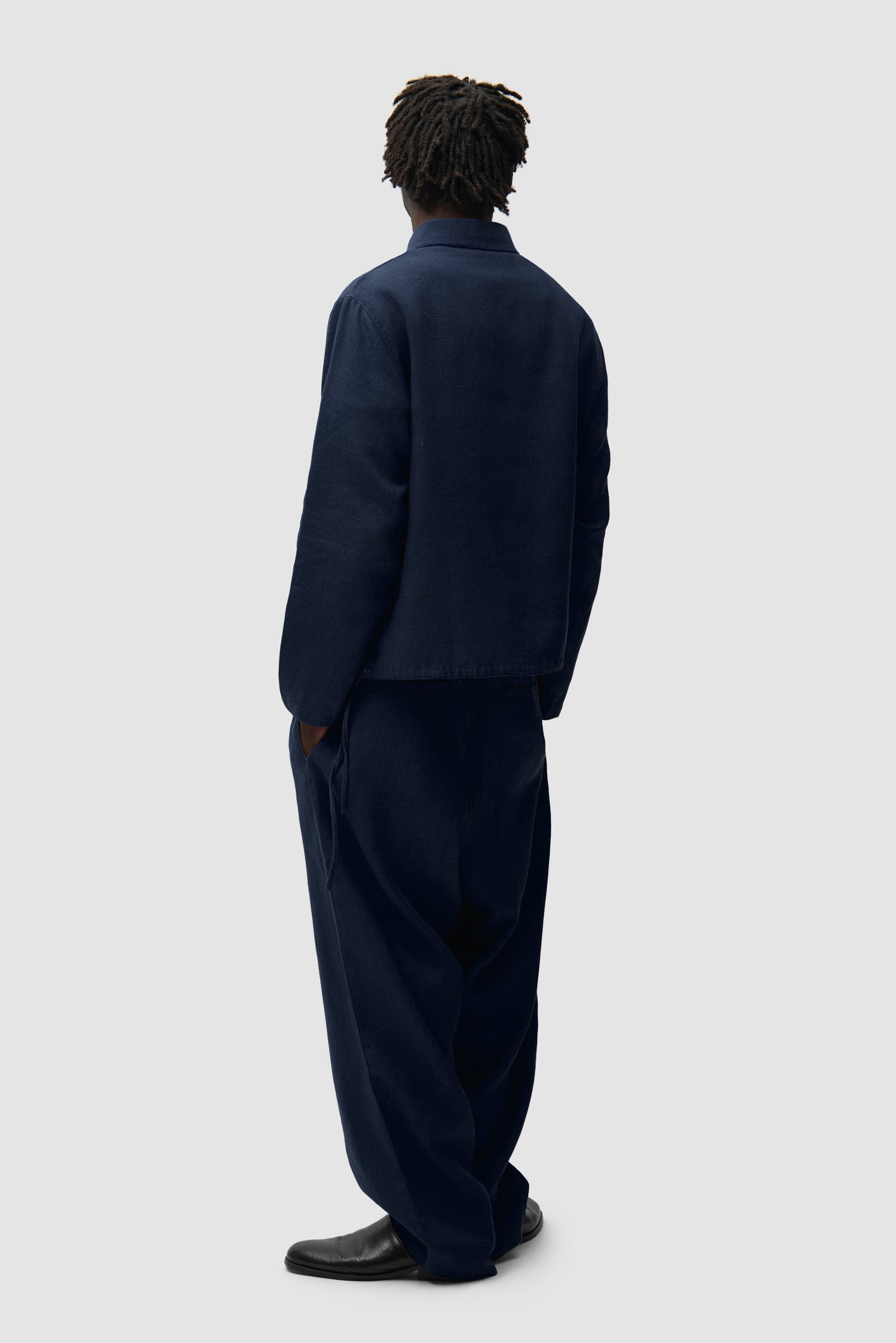 Linen Pants in Navy worn by a model, full-body back view