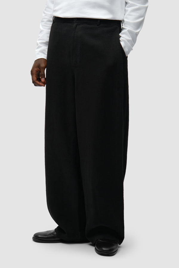 Linen Suit Pants in Black worn by a model, half-body side view