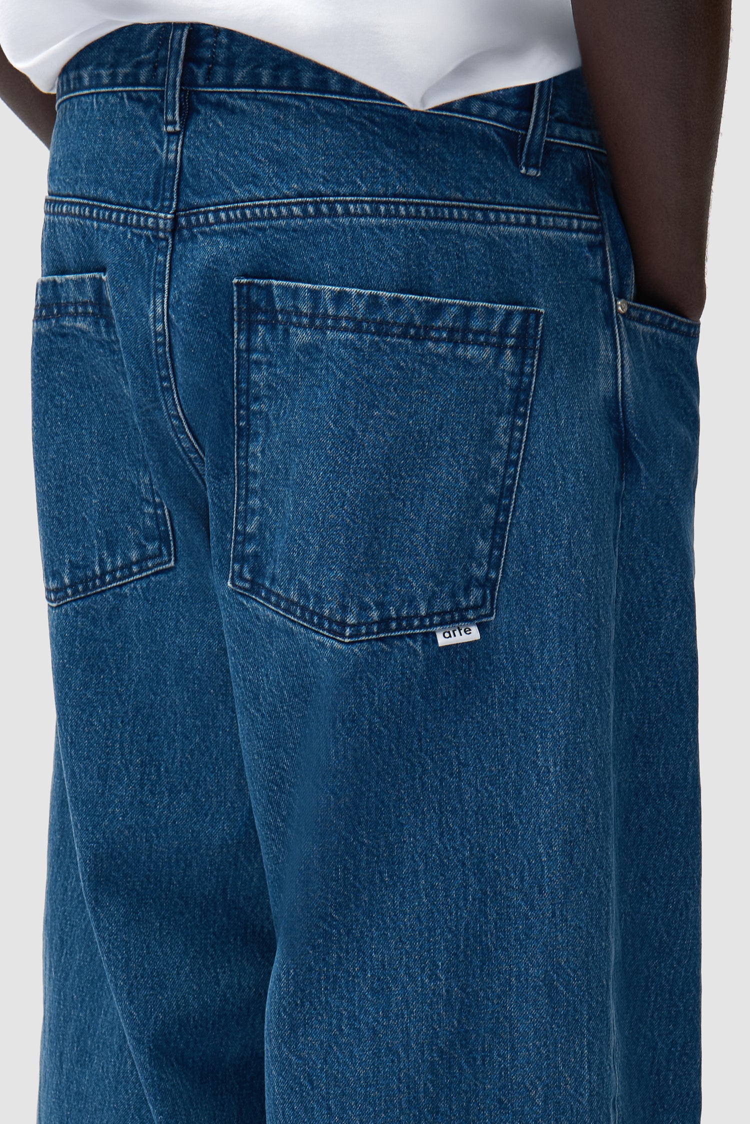 Detail view of Baggy Pants in Raw Denim, showing back pockets and logo