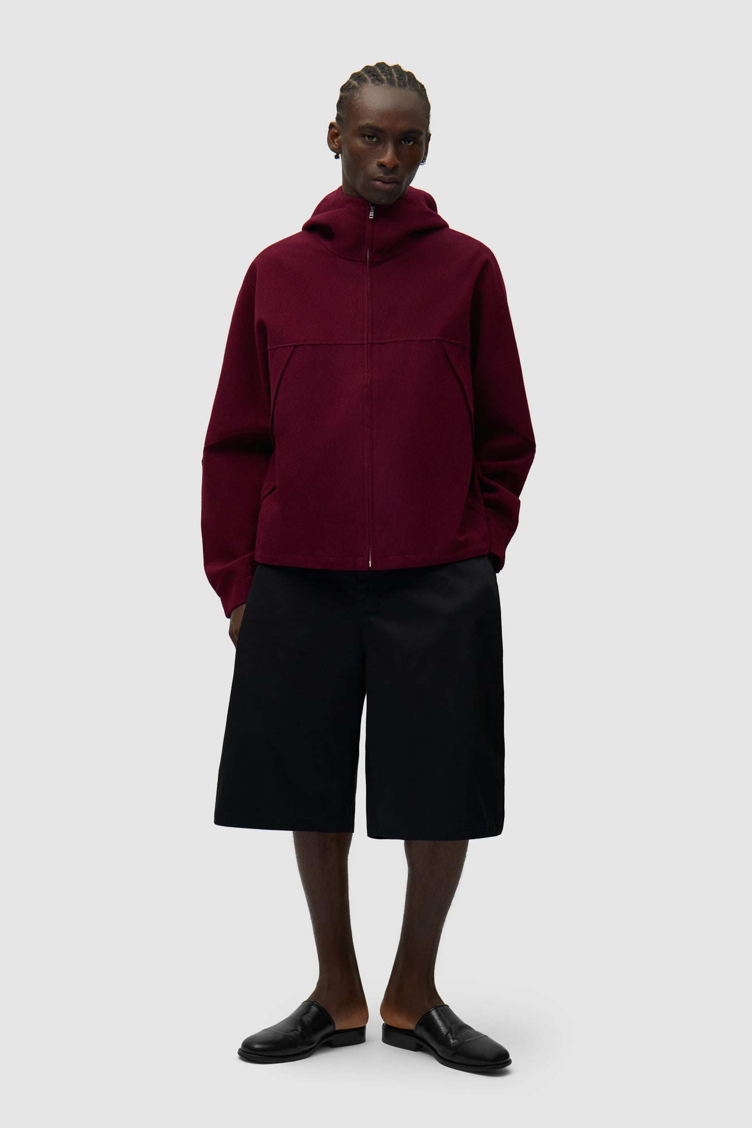 Veste technique en laine bordeaux portée par un mannequin, vue de profil en pied