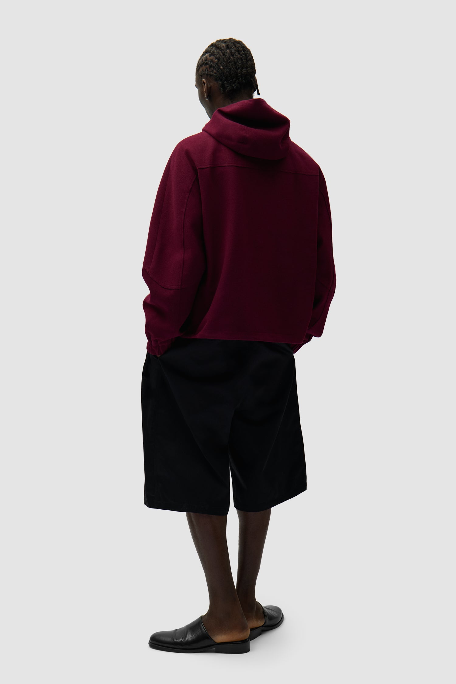 Veste technique en laine bordeaux portée par un mannequin, vue arrière en pied
