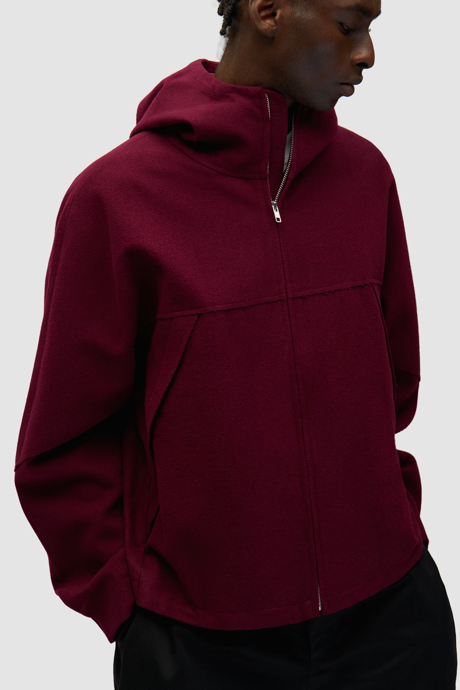 Veste technique en laine bordeaux portée par un mannequin, vue de profil à mi-corps