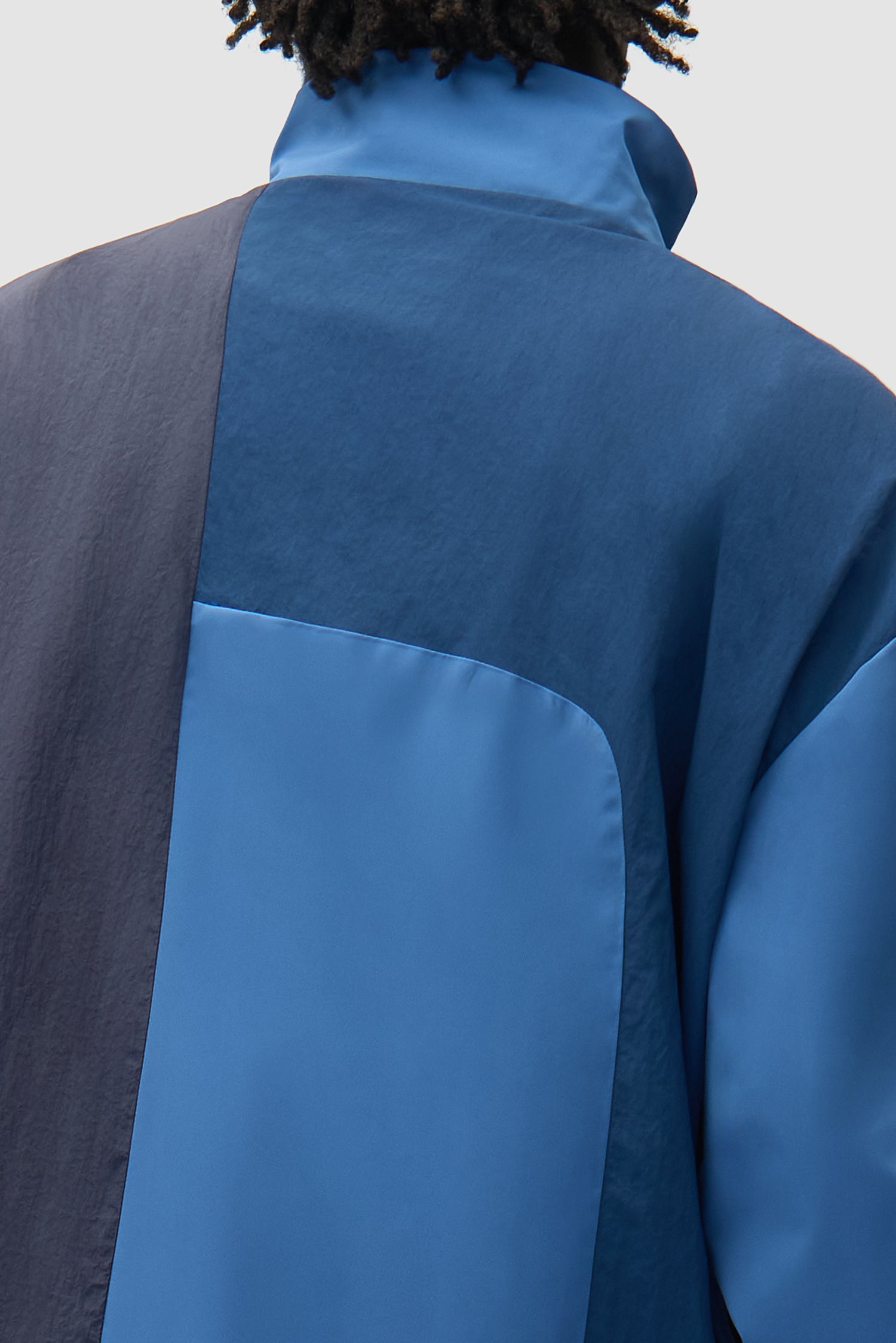 Detail view of Curve Zipper Jacket in Blue, showing back panel