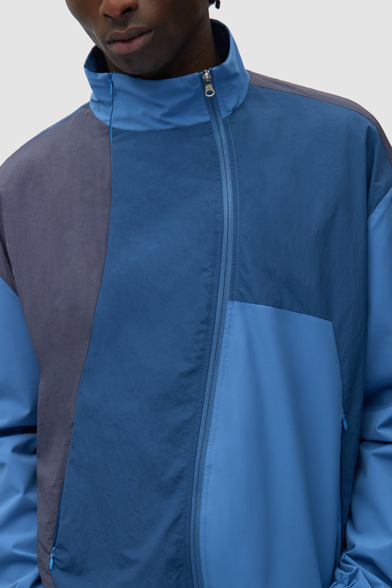 Vue détaillée de la veste zippée Curve en bleu, montrant la fermeture éclair à l'avant.