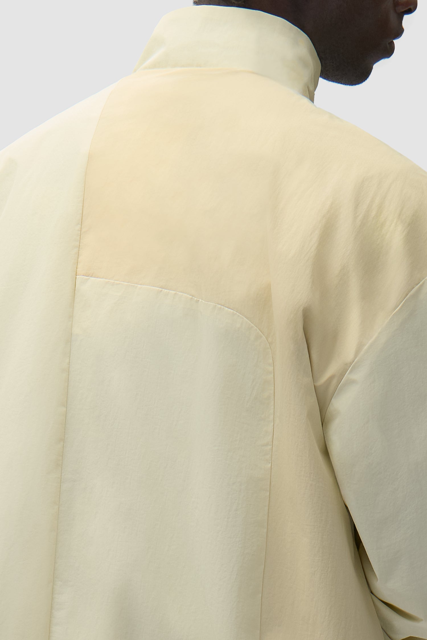 Detail view of Curve Zipper Jacket in Cream, showing back panel