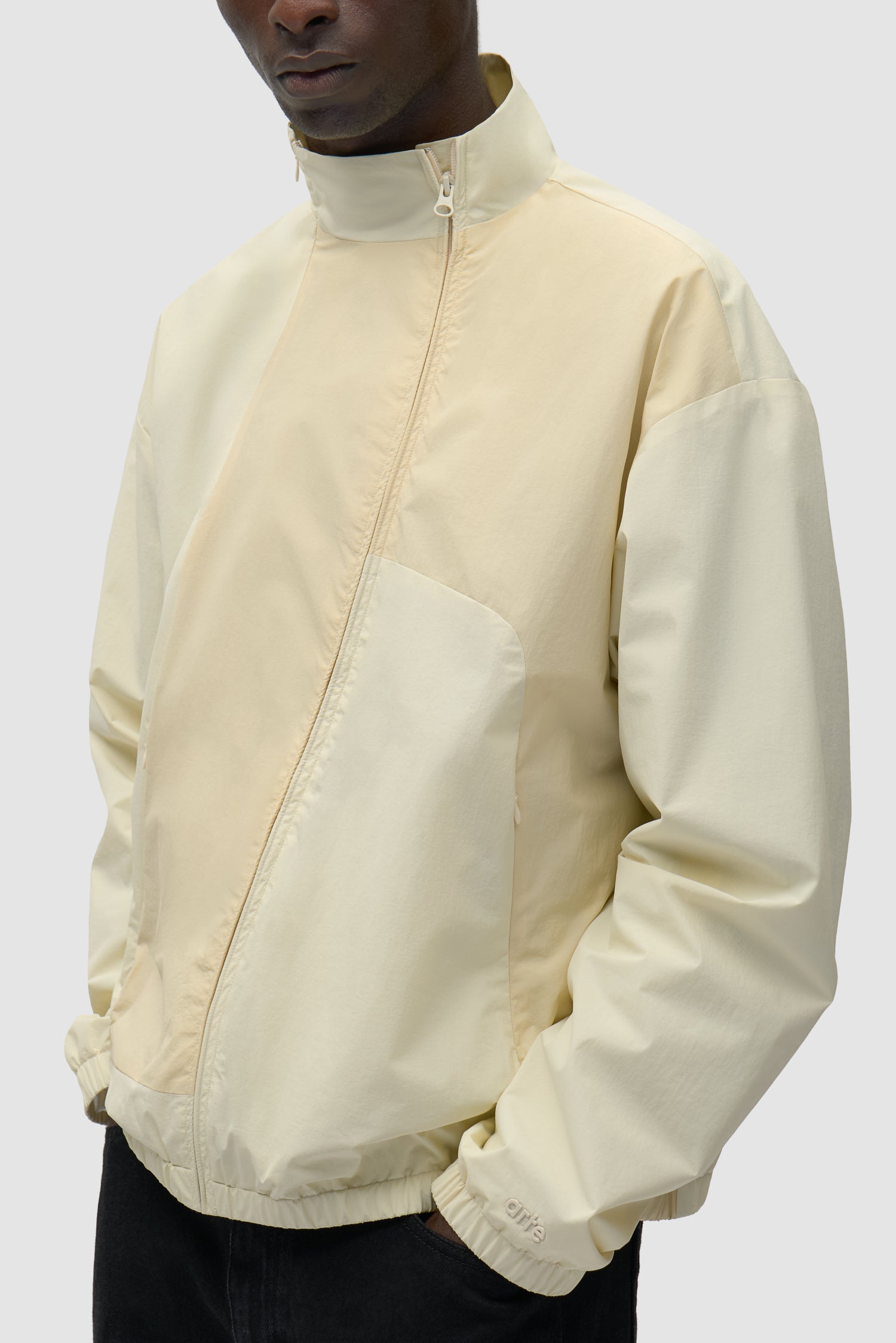 Vue détaillée de la veste zippée Curve en crème, montrant la fermeture éclair