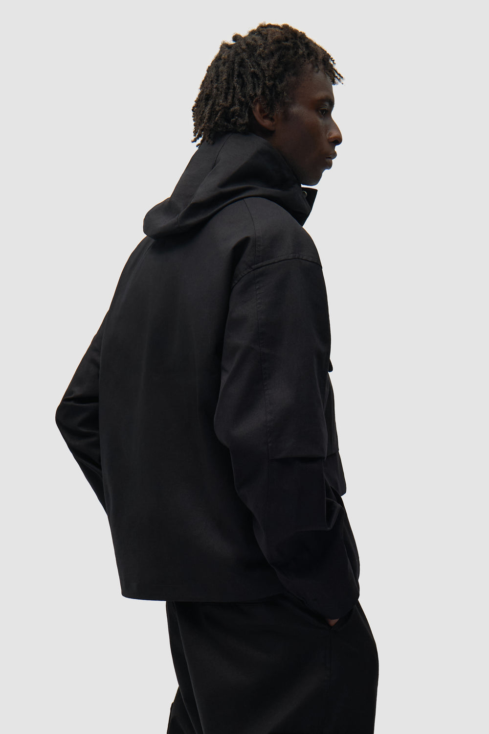 Veste technique en lin noir portée par un mannequin, vue de dos à mi-corps