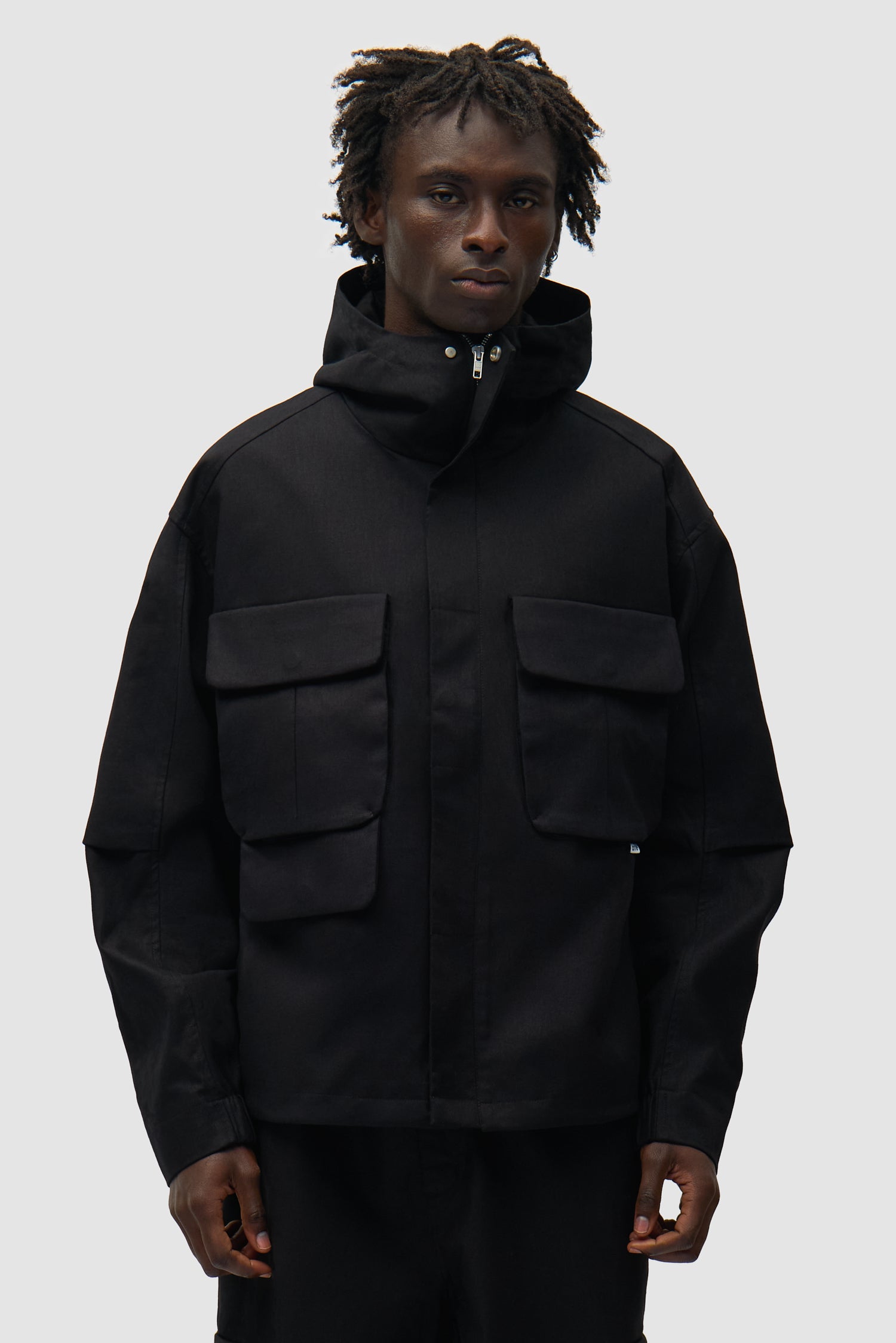 Veste technique en lin noir portée par un mannequin, vue de face en demi-corps