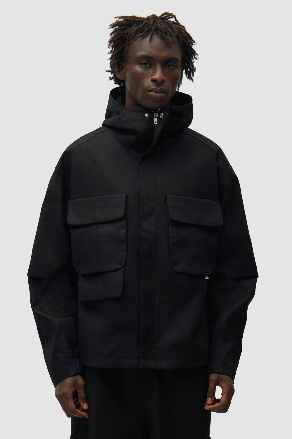 Veste technique en lin noir portée par un mannequin, vue de face en demi-corps