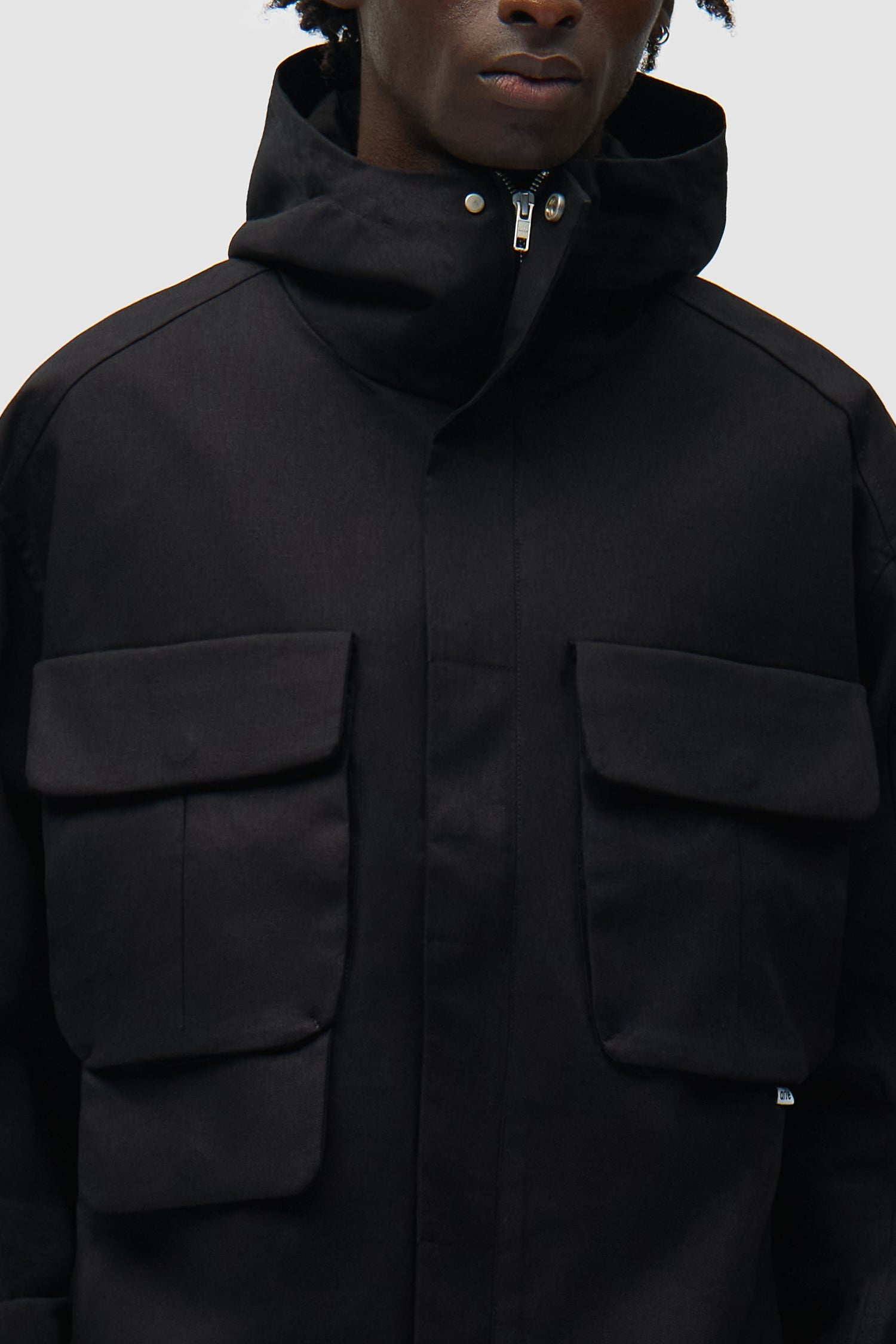 Vue détaillée de la veste technique en lin noir, avec logo