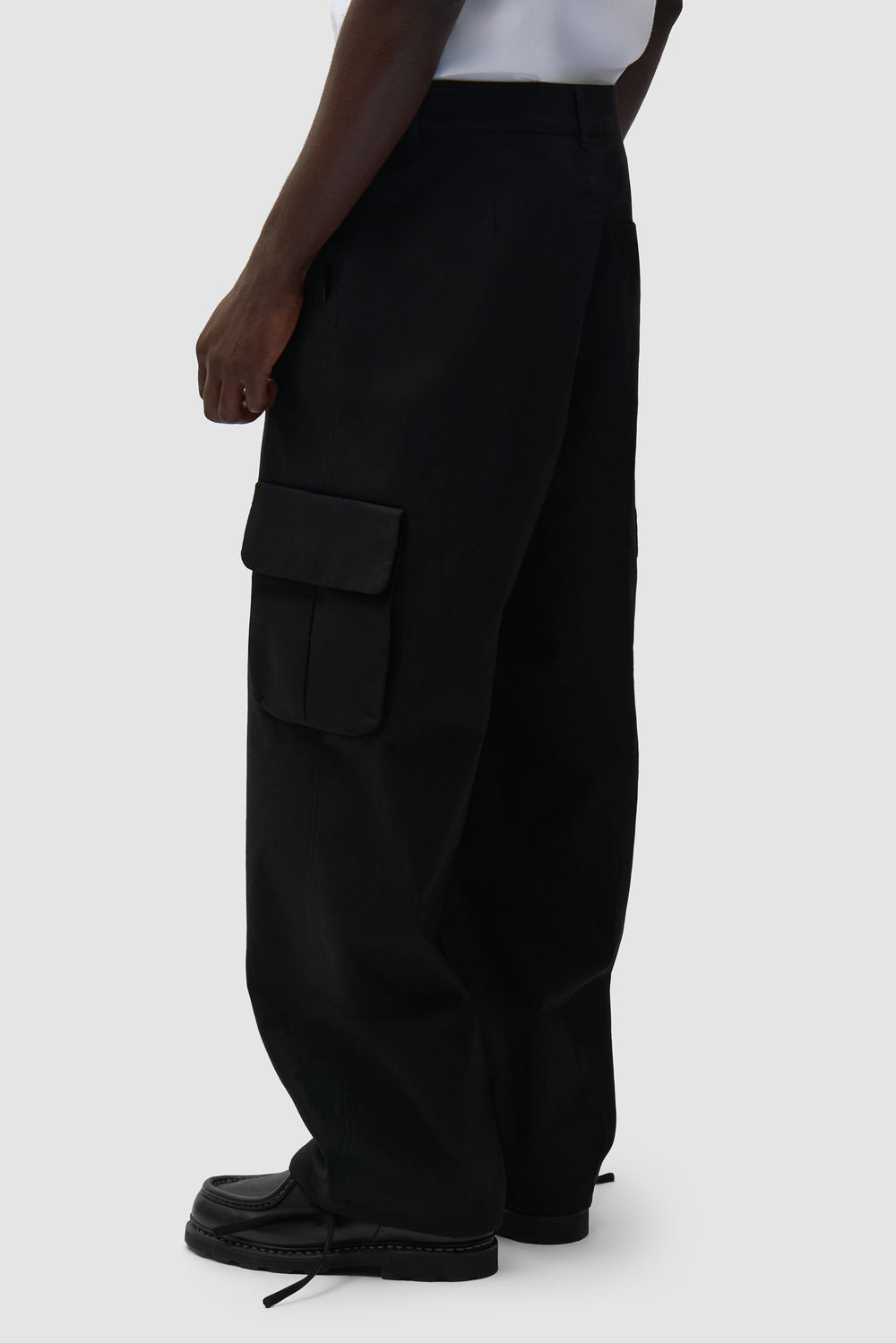 Pantalon cargo en lin noir porté par un mannequin, vue de profil à mi-corps
