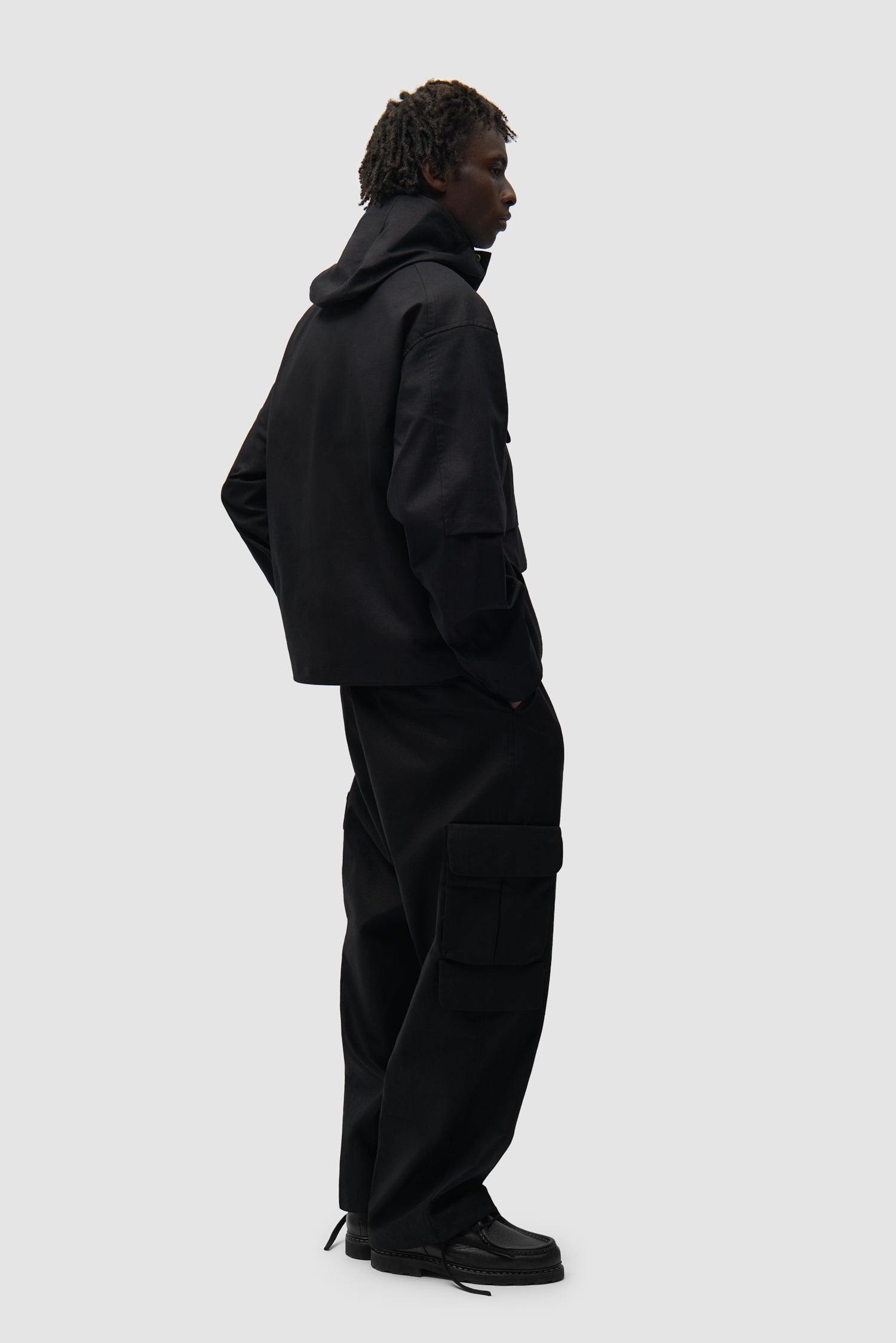 Pantalon cargo en lin noir porté par un mannequin, vue de profil en pied