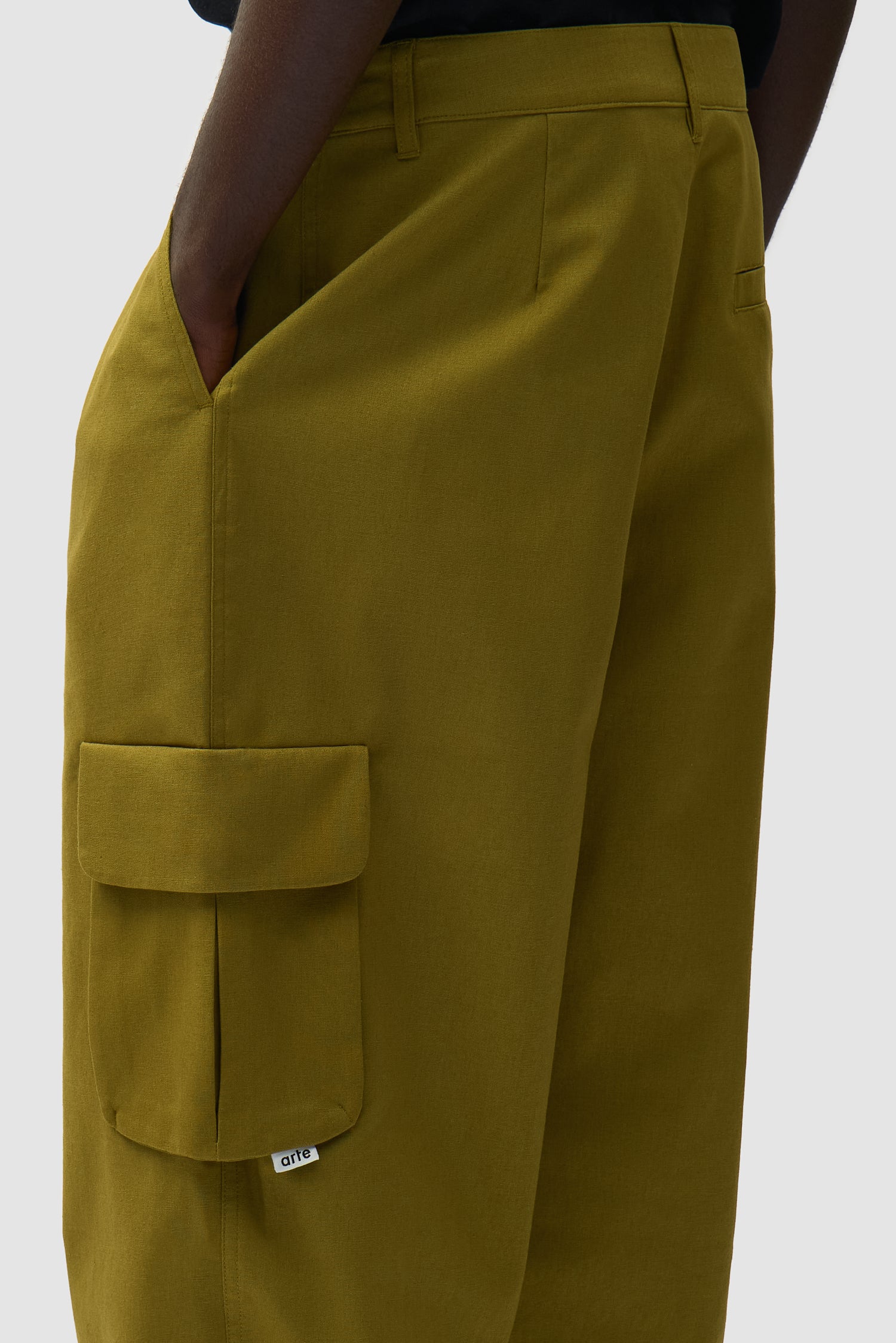 Vue détaillée du pantalon cargo en lin vert, avec logo