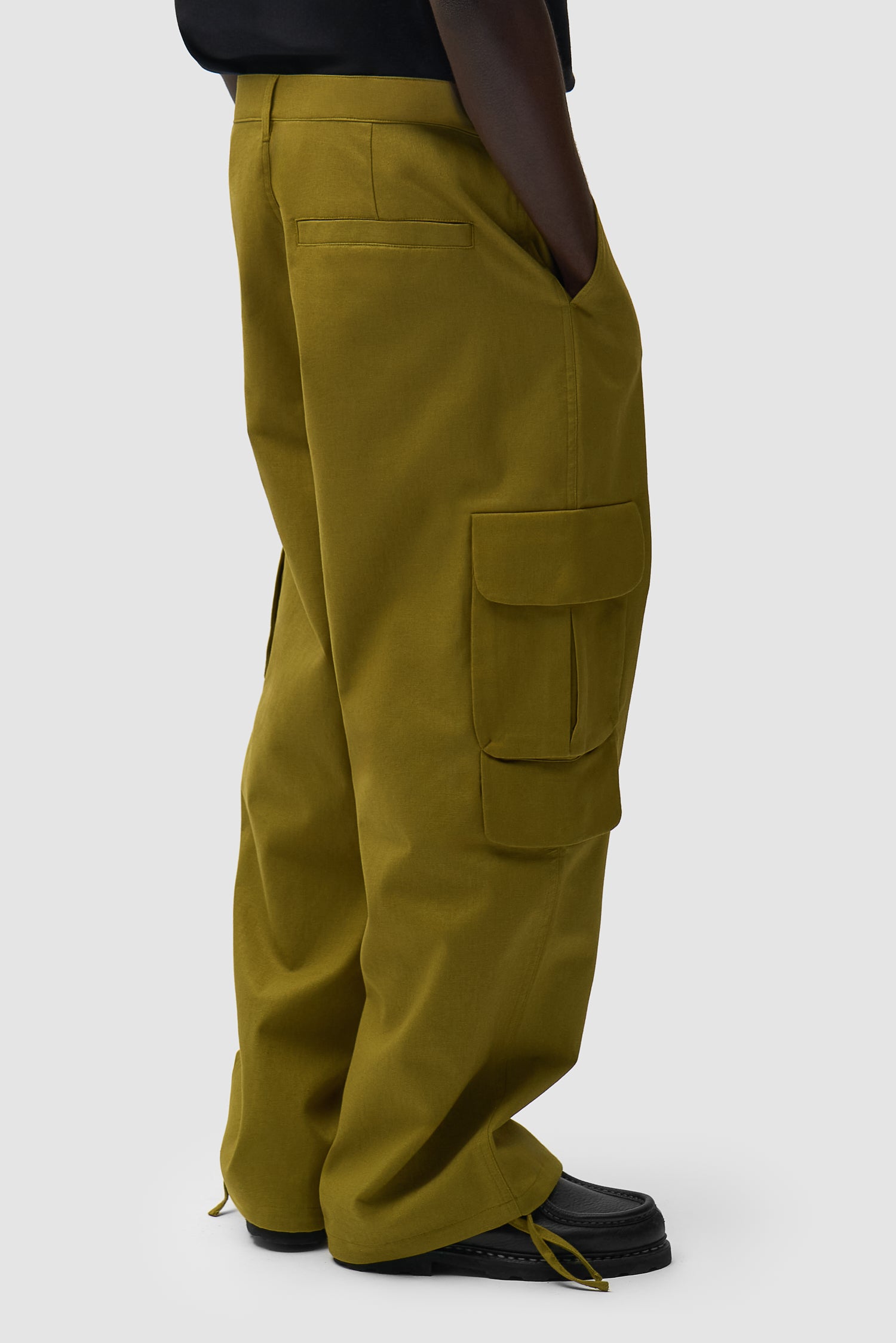 Pantalon cargo en lin vert porté par un mannequin, vue de dos à mi-corps