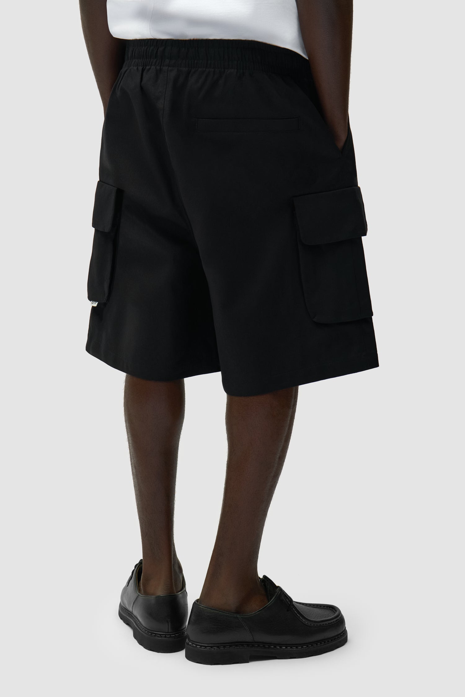 Short cargo en lin noir porté par un mannequin, vue arrière à mi-corps