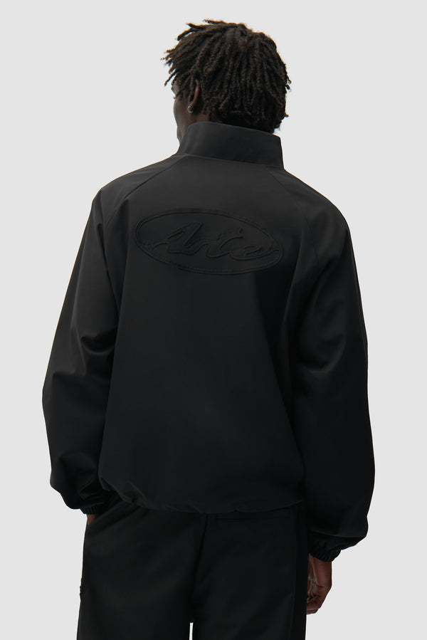 Veste de survêtement de marque noire portée par un mannequin, vue de dos à mi-corps