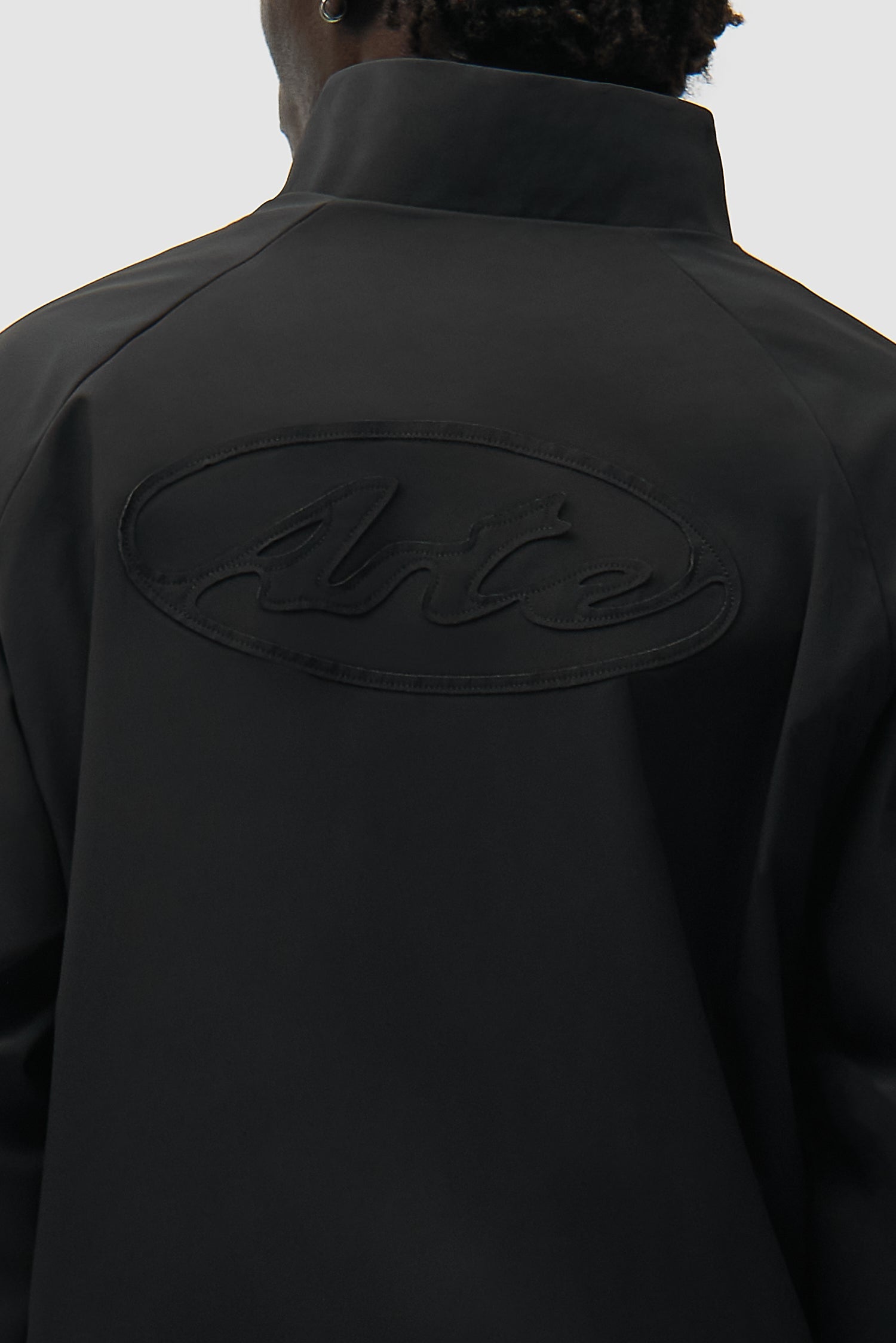 Detail view of Branded Trackjacket in Black, showing back logo