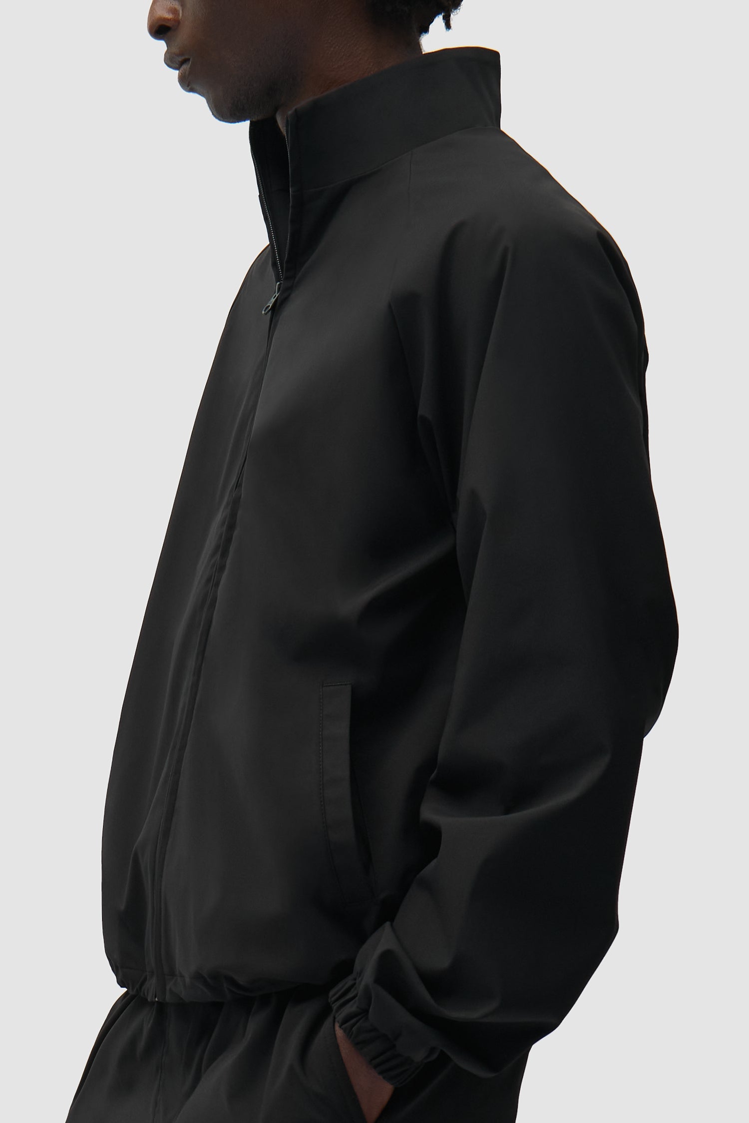 Branded Trackjacket in Black worn by a model, half-body side view