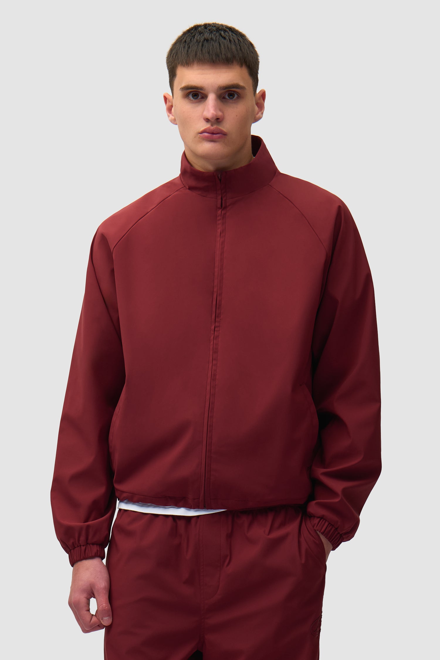 Branded Trackjacket in Bordeaux worn by a model, half-body front view