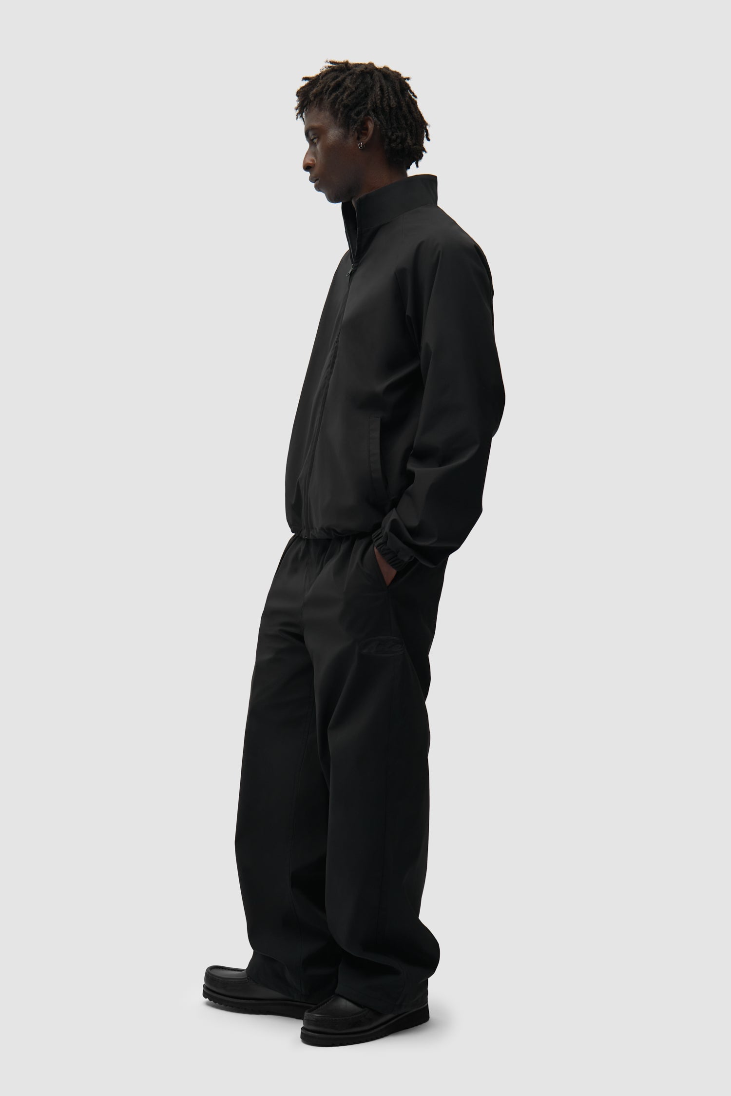 Pantalon de survêtement de marque noir porté par un mannequin, vue de face en pied