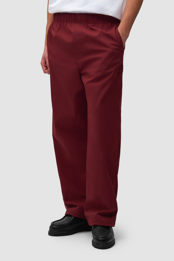 Branded Track Pants in Bordeaux worn by a model, half-body front view