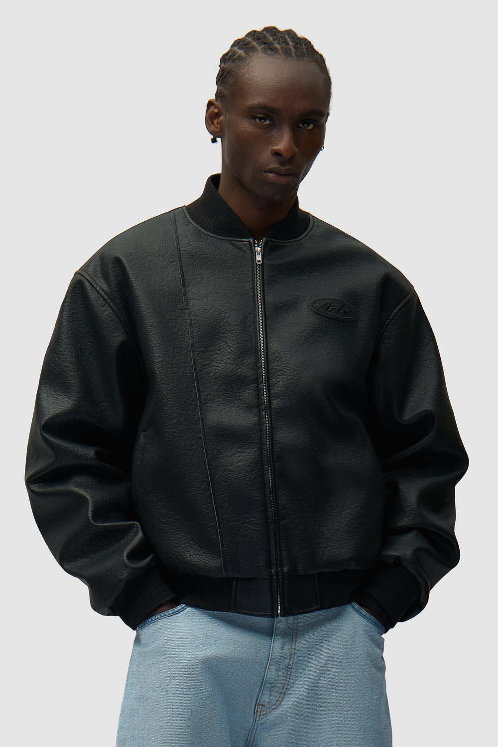 Veste universitaire en cuir noir portée par un mannequin, vue de face en demi-corps