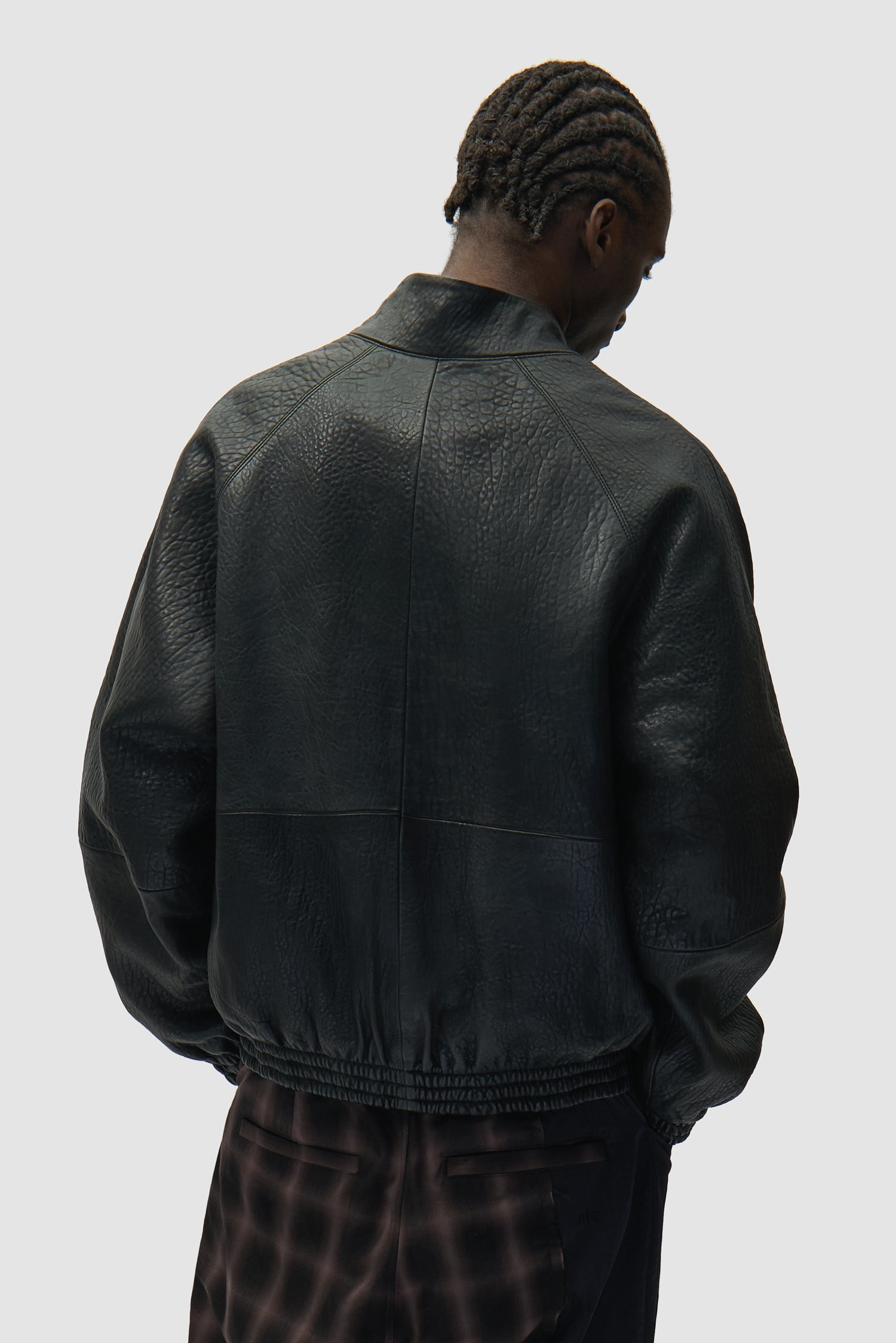 Veste en cuir à col haut, couleur noire, portée par un mannequin, vue de dos, demi-corps