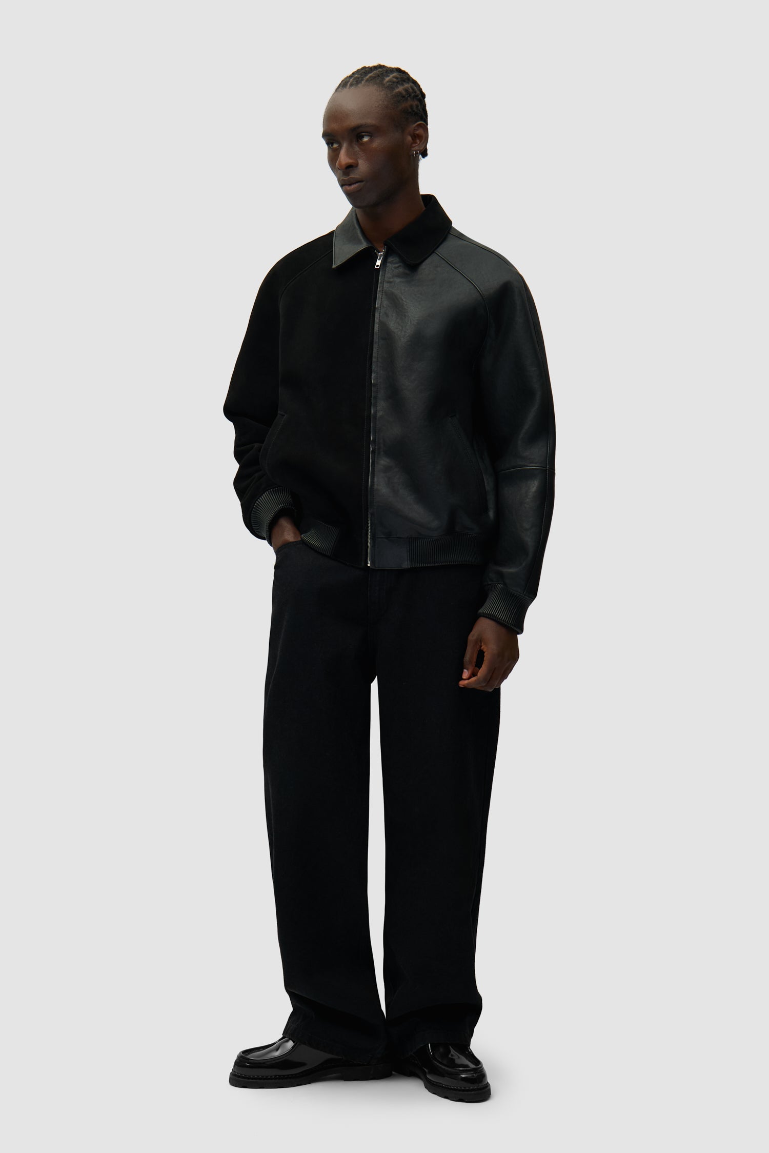 Veste en cuir noir portée par un mannequin, vue de profil en pied